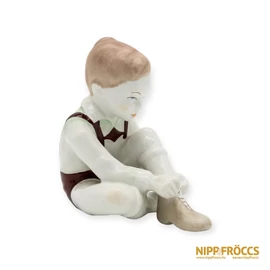 Aquincumi porcelán - Cipőt húzó kisfiú
