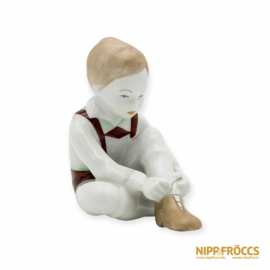 Aquincumi porcelán - Cipőt húzó kisfiú